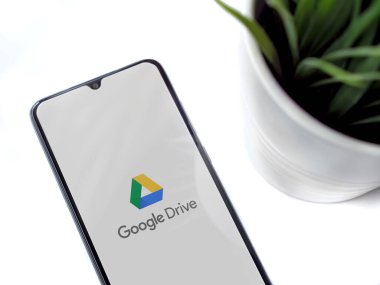 Lod, Israel - 8 Temmuz 2020: Google Drive uygulama ekranlı siyah cep telefonlu modern minimalist ofis çalışma alanı. Üst görünüm düzlüğü kopyalama alanı ile yatıyordu.