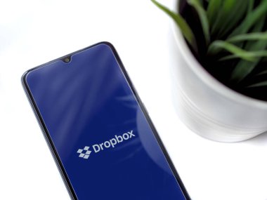 Lod, Israel - 8 Temmuz 2020: Siyah cep telefonlu, Dropbox uygulamalı, beyaz arka planda logosu olan modern minimalist ofis çalışma alanı. Üst görünüm düzlüğü kopyalama alanı ile yatıyordu.