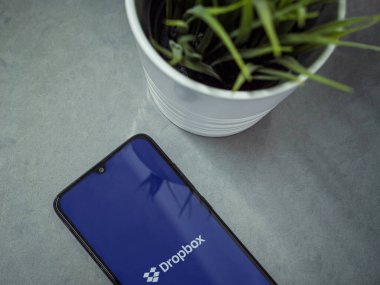 Lod, Israel - 8 Temmuz 2020: Mermer zemin üzerinde logosu olan siyah cep telefonlu modern minimalist ofis çalışma alanı. Üst görünüm düzlüğü kopyalama alanı ile yatıyordu.