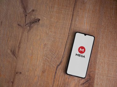Lod, Israel - 8 Temmuz 2020: MeGA uygulama başlatma ekranı üzerinde logo olan siyah bir cep telefonu ahşap arka planda. Üst görünüm düzlüğü kopyalama alanı ile yatıyordu.