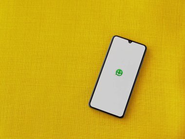 Lod, Israel - 8 Temmuz 2020: Sarı kumaş arka planda siyah bir cep telefonunun logosu olan Scriby uygulama başlatma ekranı. Üst görünüm düzlüğü kopyalama alanı ile yatıyordu.