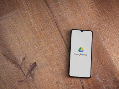 Lod, Israel - 8 Temmuz 2020: Google Drive uygulama ekranıyla birlikte tahta arka planda siyah bir cep telefonunun logosu görülüyor. Üst görünüm düzlüğü kopyalama alanı ile yatıyordu.