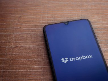 Lod, Israel - 8 Temmuz 2020: Dropbox uygulama ekranı üzerinde siyah bir cep telefonunun amblemi olan tahta arka planda. Üst görünüm düzlüğü kopyalama alanı ile yatıyordu.
