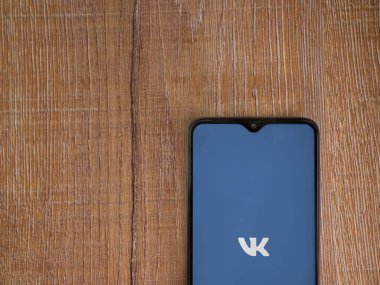 Lod, Israel - 8 Temmuz 2020: VK uygulama ekranı üzerinde siyah bir cep telefonunun amblemi olan tahta arka planda. Üst görünüm düzlüğü kopyalama alanı ile yatıyordu.
