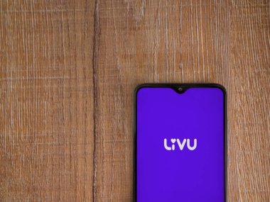 Lod, Israel - 8 Temmuz 2020: LiveU uygulama ekranı üzerinde logo olan siyah bir cep telefonu ahşap arka planda. Üst görünüm düzlüğü kopyalama alanı ile yatıyordu.