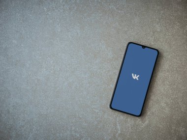 Lod, Israel - 8 Temmuz 2020: VK uygulama ekranı seramik taş zemin üzerinde siyah bir cep telefonunun logosu var. Üst görünüm düzlüğü kopyalama alanı ile yatıyordu.