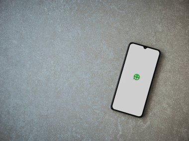 Lod, Israel - 8 Temmuz 2020: Seramik taş zemin üzerinde siyah bir cep telefonunun logosu olan Scriby uygulama başlatma ekranı. Üst görünüm düzlüğü kopyalama alanı ile yatıyordu.