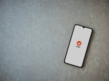 Lod, Israel - 8 Temmuz 2020: Seramik taş zemin üzerinde siyah bir cep telefonunun logosu olan Reddit uygulaması fırlatma ekranı. Üst görünüm düzlüğü kopyalama alanı ile yatıyordu.