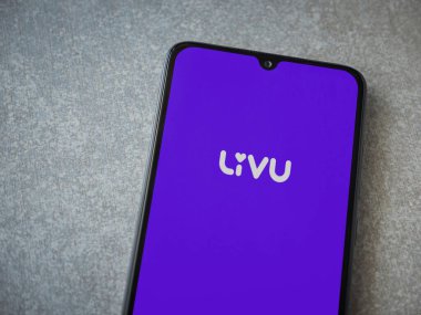 Lod, Israel - 8 Temmuz 2020: LiveU uygulama ekranıyla seramik taş zemin üzerinde siyah bir cep telefonu görüntüsü. Üst görünüm düzlüğü kopyalama alanı ile yatıyordu.