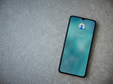 Lod, Israel - 8 Temmuz 2020: Eyecon uygulaması seramik taş zemin üzerinde siyah bir cep telefonunun logosu olan fırlatma ekranı. Üst görünüm düzlüğü kopyalama alanı ile yatıyordu.