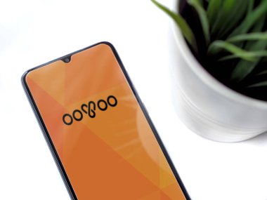 Lod, Israel - 8 Temmuz 2020: Beyaz arka planda logosu olan siyah cep telefonlu modern minimalist ofis çalışma alanı. Üst görünüm düzlüğü kopyalama alanı ile yatıyordu.