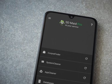 Lod, Israel - 8 Temmuz 2020: SD Maid uygulaması seramik taş zemin üzerinde siyah bir cep telefonunun logosu olan fırlatma ekranı. Üst görünüm düzlüğü kopyalama alanı ile yatıyordu.