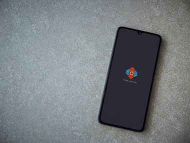 Lod, Israel - 8 Temmuz 2020: Nova Launcher uygulaması seramik taş zemin üzerinde siyah bir cep telefonunun logosu olan fırlatma ekranı. Üst görünüm düzlüğü kopyalama alanı ile yatıyordu.