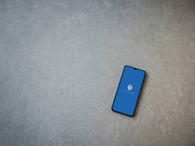 Lod, Israel - 8 Temmuz 2020: Microsoft Authenticator uygulaması seramik taş zemin üzerinde siyah bir cep telefonunun logosu olan fırlatma ekranı. Üst görünüm düzlüğü kopyalama alanı ile yatıyordu.
