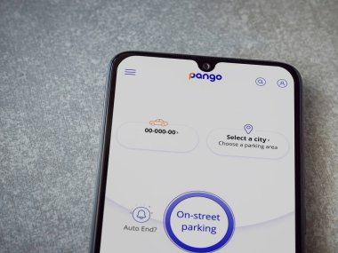 Lod, Israel - 8 Temmuz 2020: Pango uygulaması seramik taş zemin üzerinde siyah bir cep telefonunun logosu olan fırlatma ekranı. Üst görünüm düzlüğü kopyalama alanı ile yatıyordu.