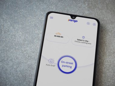 Lod, Israel - 8 Temmuz 2020: Pango uygulaması seramik taş zemin üzerinde siyah bir cep telefonunun logosu olan fırlatma ekranı. Üst görünüm düzlüğü kopyalama alanı ile yatıyordu.