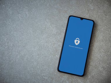 Lod, Israel - 8 Temmuz 2020: Microsoft Authenticator uygulaması seramik taş zemin üzerinde siyah bir cep telefonunun logosu olan fırlatma ekranı. Üst görünüm düzlüğü kopyalama alanı ile yatıyordu.