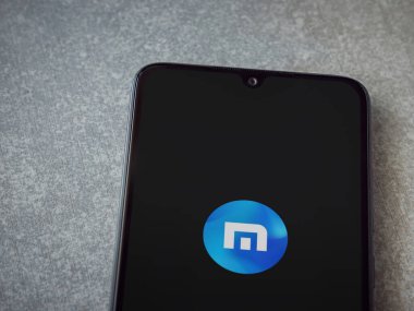 Lod, Israel - 8 Temmuz 2020: Maxthon Tarayıcı uygulaması seramik taş zemin üzerinde siyah bir cep telefonunun logosu olan fırlatma ekranı. Üst görünüm düzlüğü kopyalama alanı ile yatıyordu.