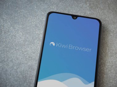 Lod, Israel - 8 Temmuz 2020: Kiwi Tarayıcı uygulaması seramik taş zemin üzerinde siyah bir cep telefonunun logosu olan fırlatma ekranı. Üst görünüm düzlüğü kopyalama alanı ile yatıyordu.