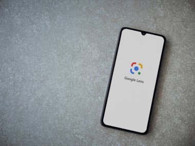 Lod, Israel - 8 Temmuz 2020: Google Lens uygulama ekranı seramik taş zemin üzerinde siyah bir cep telefonunun logosu var. Üst görünüm düzlüğü kopyalama alanı ile yatıyordu.