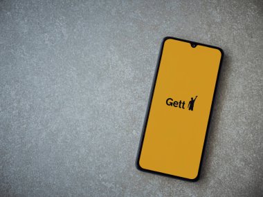 Lod, Israel - 8 Temmuz 2020: Seramik taş zemin üzerinde siyah bir cep telefonunun logosu olan Gett uygulaması fırlatma ekranı. Üst görünüm düzlüğü kopyalama alanı ile yatıyordu.