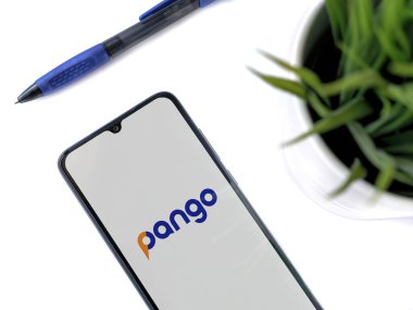 Lod, Israel - 8 Temmuz 2020: Pango uygulama ekranlı siyah cep telefonlu modern minimalist ofis çalışma alanı. Üst görünüm düzlüğü kopyalama alanı ile yatıyordu.