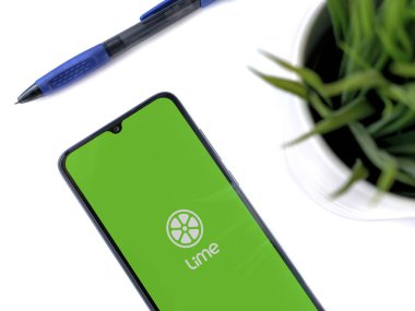 Lod, Israel - 8 Temmuz 2020: Beyaz arka planda logosu olan siyah cep telefonlu modern minimalist ofis çalışma alanı. Üst görünüm düzlüğü kopyalama alanı ile yatıyordu.