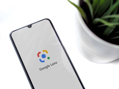 Lod, Israel - 8 Temmuz 2020: Google Lens uygulama ekranlı siyah cep telefonlu modern minimalist ofis çalışma alanı. Üst görünüm düzlüğü kopyalama alanı ile yatıyordu.