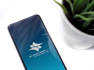 Lod, Israel - 8 Temmuz 2020: Ben Gurion Havaalanı uygulama ekranlı siyah cep telefonlu modern minimalist ofis çalışma alanı. Üst görünüm düzlüğü kopyalama alanı ile yatıyordu.