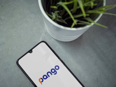 Lod, Israel - 8 Temmuz 2020: Pango uygulama ekranlı ve mermer zemin üzerinde logosu olan siyah cep telefonlu modern minimalist ofis çalışma alanı. Üst görünüm düzlüğü kopyalama alanı ile yatıyordu.