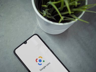 Lod, Israel - 8 Temmuz 2020: Google Lens uygulama ekranlı ve mermer zemin üzerinde logosu olan siyah cep telefonlu modern minimalist ofis çalışma alanı. Üst görünüm düzlüğü kopyalama alanı ile yatıyordu.