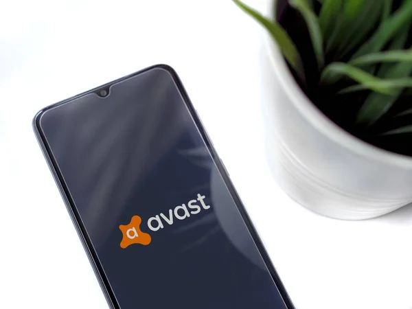 Lod, Israel - 8 Temmuz 2020: Beyaz arka planda logosu olan Avast Antivirüs uygulama ekranlı siyah cep telefonlu modern minimalist ofis çalışma alanı. Üst görünüm düzlüğü kopyalama alanı ile yatıyordu.