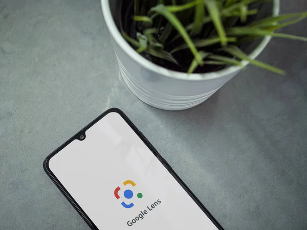 Lod, Israel - 8 Temmuz 2020: Google Lens uygulama ekranlı ve mermer zemin üzerinde logosu olan siyah cep telefonlu modern minimalist ofis çalışma alanı. Üst görünüm düzlüğü kopyalama alanı ile yatıyordu.