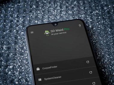 Lod, Israel - 8 Temmuz 2020: SD Maid uygulaması, metalik arka planda siyah bir cep telefonunun logosu ile fırlatma ekranı. Üst görünüm yatağını kapat.