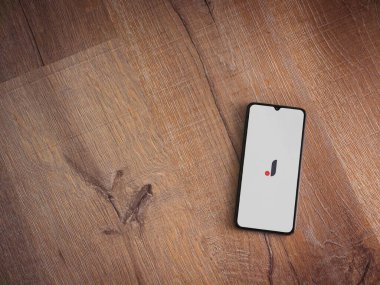 Lod, Israel - 8 Temmuz 2020: Ahşap arka planda siyah bir cep telefonunun logosu olan Joom uygulaması fırlatma ekranı. Üst görünüm düzlüğü kopyalama alanı ile yatıyordu.