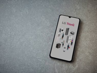Lod, Israel - 8 Temmuz 2020: LG ThinQ uygulama ekranı seramik taş zemin üzerinde siyah bir cep telefonunun logosu var. Üst görünüm düzlüğü kopyalama alanı ile yatıyordu.