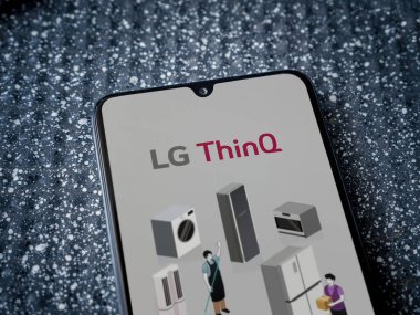 Lod, Israel - 8 Temmuz 2020: LG ThinQ uygulama ekranı metalik arka planda siyah bir cep telefonunun logosu var. Üst görünüm yatağını kapat.