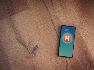 Lod, Israel - 8 Temmuz 2020: Ahşap arka planda siyah bir cep telefonunun logosunda logo bulunan uygulama ekranı. Üst görünüm düzlüğü kopyalama alanı ile yatıyordu.