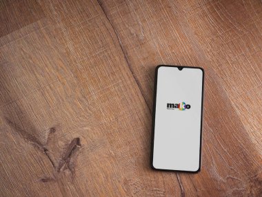 Lod, Israel - 8 Temmuz 2020: Ahşap arka planda siyah bir cep telefonunun logosu olan mako uygulama başlatma ekranı. Üst görünüm düzlüğü kopyalama alanı ile yatıyordu.