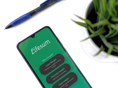 Lod, Israel - 8 Temmuz 2020: Beyaz arka planda logosu olan siyah cep telefonlu modern minimalist ofis çalışma alanı. Üst görünüm düzlüğü kopyalama alanı ile yatıyordu.