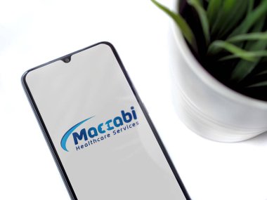 Lod, Israel - 8 Temmuz 2020: Beyaz arka planda logosu olan siyah cep telefonlu modern minimalist ofis çalışma alanı. Üst görünüm düzlüğü kopyalama alanı ile yatıyordu.