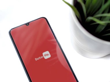 Lod, Israel - 8 Temmuz 2020: Beyaz arka planda logosu olan siyah cep telefonlu modern minimalist ofis çalışma alanı. Üst görünüm düzlüğü kopyalama alanı ile yatıyordu.