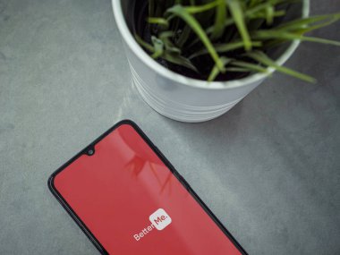 Lod, Israel - 8 Temmuz 2020: Mermer zemin üzerinde logosu olan siyah cep telefonlu modern minimalist ofis çalışma alanı. Üst görünüm düzlüğü kopyalama alanı ile yatıyordu.