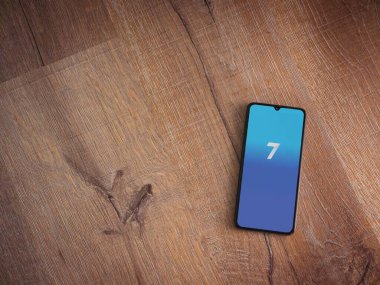 Lod, Israel - 8 Temmuz 2020: Ahşap arka planda siyah bir cep telefonunun logosu olan yedi uygulama fırlatma ekranı. Üst görünüm düzlüğü kopyalama alanı ile yatıyordu.