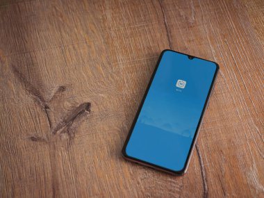 Lod, Israil - 8 Temmuz 2020: Mi Fit uygulaması uygulama ekranıyla ahşap arka planda siyah bir cep telefonunun logosu. Üst görünüm düzlüğü kopyalama alanı ile yatıyordu.