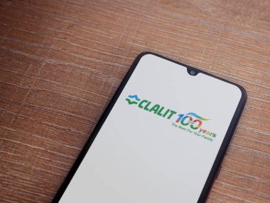 Lod, Israel - 8 Temmuz 2020: Clalit Sağlık Hizmetleri uygulama ekranı üzerinde siyah bir cep telefonunun ahşap arka planda sergilendiği logo. Üst görünüm düzlüğü kopyalama alanı ile yatıyordu.