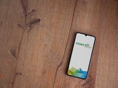 Lod, Israel - 8 Temmuz 2020: Clalit Sağlık Hizmetleri uygulama ekranı üzerinde siyah bir cep telefonunun ahşap arka planda sergilendiği logo. Üst görünüm düzlüğü kopyalama alanı ile yatıyordu.