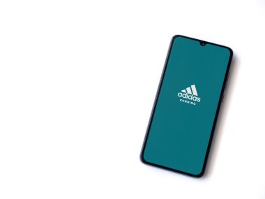 Lod, Israel - 8 Temmuz 2020: Adidas Koşan Uygulama Uygulaması beyaz arkaplanda izole edilmiş siyah bir cep telefonunun logosu ile başlatıldı. Üst görünüm düzlüğü kopyalama alanı ile yatıyordu.