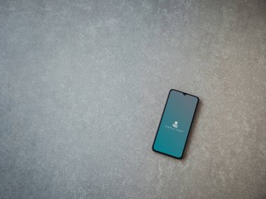 Lod, Israel - 8 Temmuz 2020: Seramik taş zemin üzerinde siyah bir cep telefonunun logosu olan Basit Alışkanlık uygulaması başlatma ekranı. Üst görünüm düzlüğü kopyalama alanı ile yatıyordu.