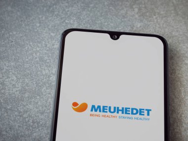 Lod, Israel - 8 Temmuz 2020: Meuhedet Sağlık Hizmetleri uygulama ekranı seramik taş zemin üzerinde siyah bir cep telefonunun logosu var. Üst görünüm düzlüğü kopyalama alanı ile yatıyordu.
